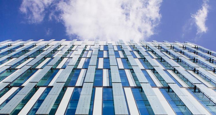 Looking up at a skyscraper against a blue sky